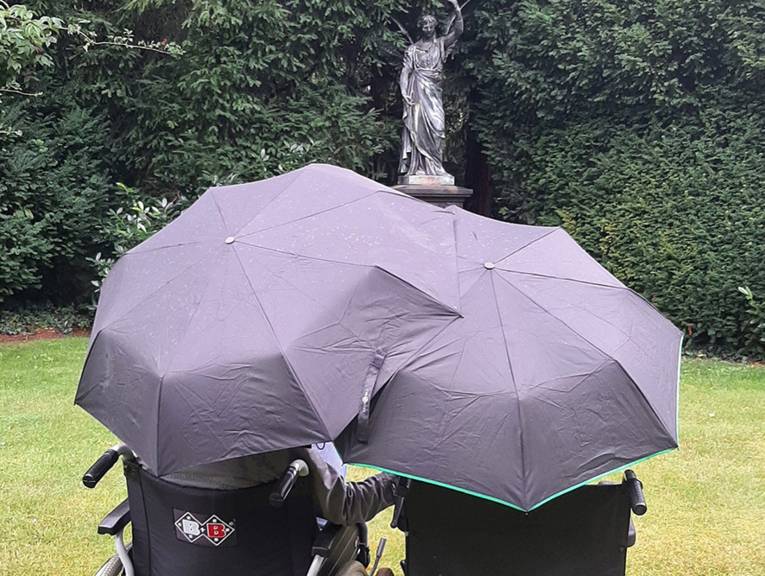 Zwei Personen unter Regenschirmen.